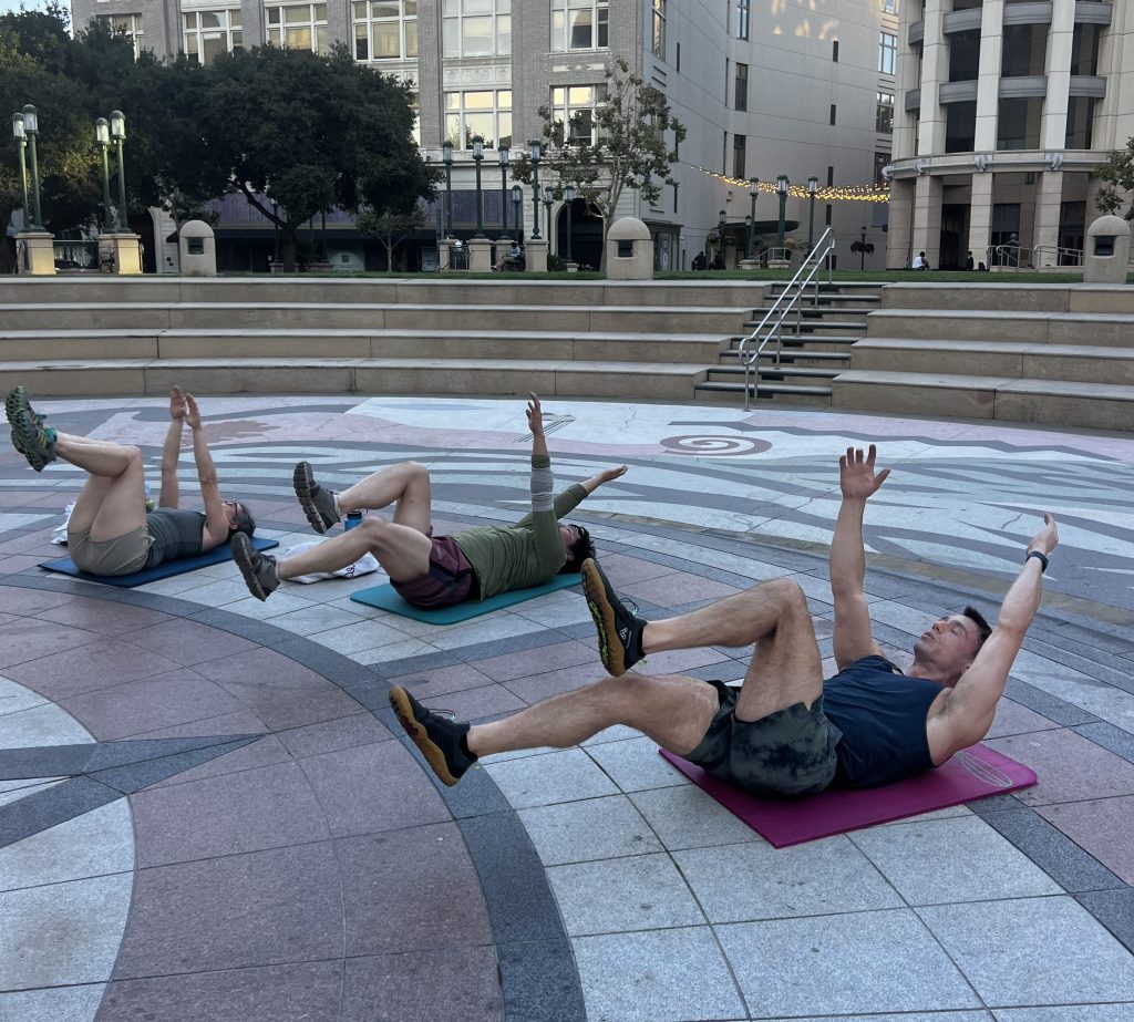 New fitness Oakland team members leading a community class outdoors in downtown Oakland